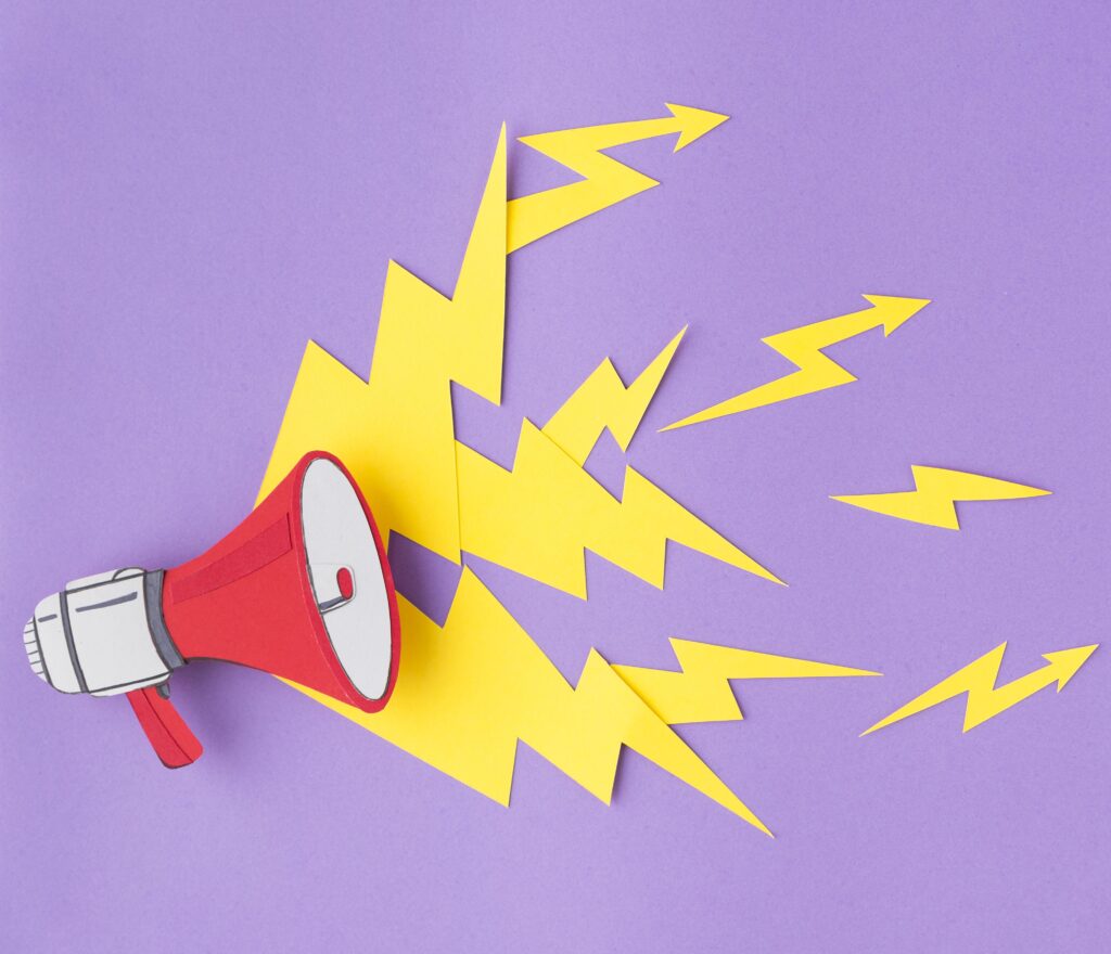 A paper cut-out of a red megaphone emitting yellow zig-zagging sound waves against a purple background.