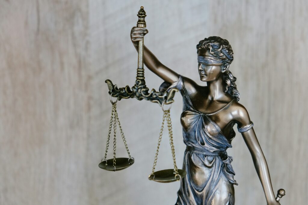 Picture of a bronze statue of Lady Justice holding a weight.